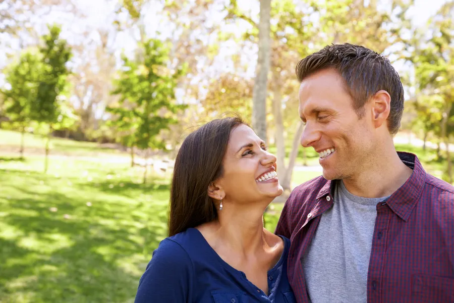 Couple smiling at each other outdoors in garden area