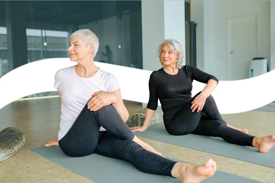 Two woman turned to the side on yoga mats